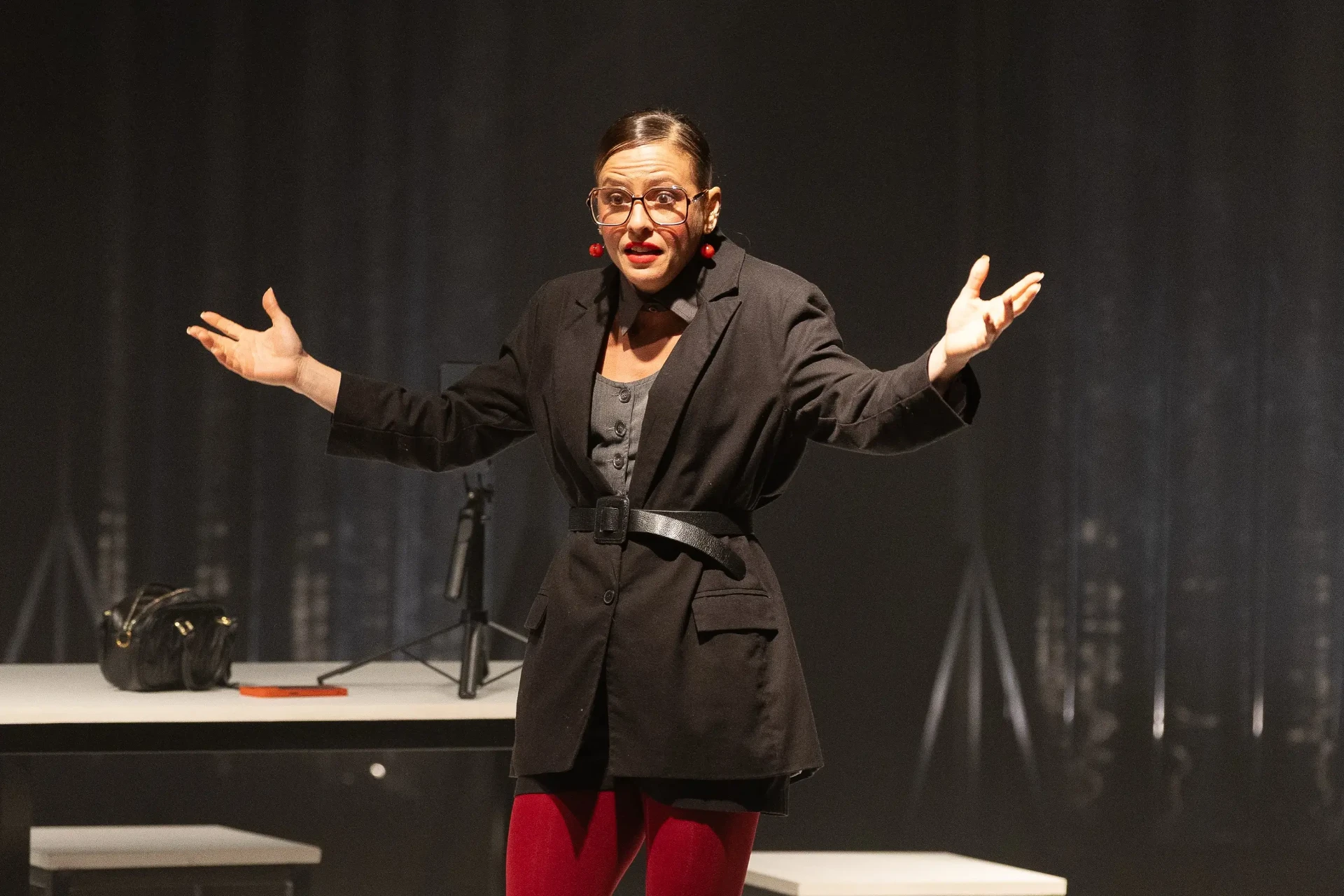 Fernanda de Freitas em cena no palco, de braços abertos